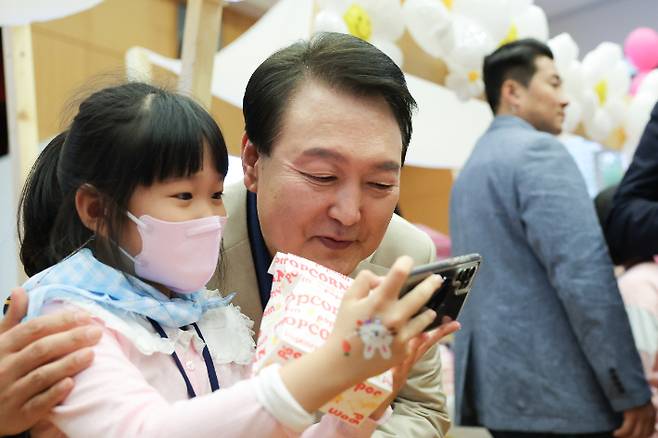 윤석열 대통령이 5일 청와대 연무관에서 열린 어린이날 초청행사에서 어린이와 셀카를 찍고 있다. 대통령실 제공