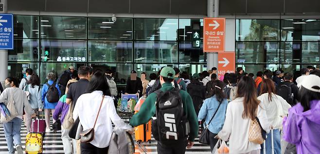 5일 오후 강한 비바람에 이틀째 무더기 결항 사태를 빚었던  제주공항에서 관광객들이 항공편 운항이 일부 재개되자 출발층으로 향하고 있다. /뉴스1