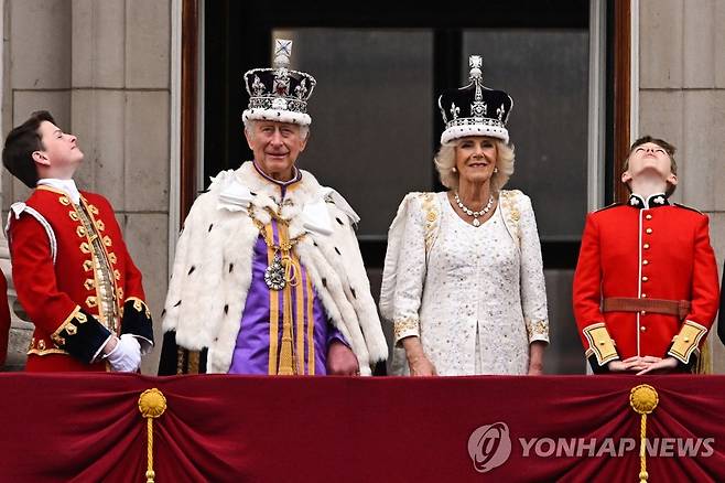 버킹엄궁 발코니에 나선 국왕 부부  (런던 AFP=연합뉴스) 찰스 3세 국왕과 커밀라 왕비가 6일(현지시간) 왕실 가족들과 함께 버킹엄궁 발코니로 나와 시민들에게 인사를 건네고 있다. 2023.5.6 photo@yna.co.kr [재판매 및 DB 금지]