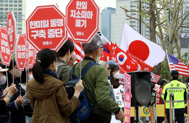 7일 오후 서울 용산구 대통령실 앞에서 시민단체 '평화와통일을여는사람들'(왼쪽)이 '한미일 동맹 구축 중단' 등 팻말을 들고 이날 한일정상회담을 규탄하는 기자회견을 열고 있다. 그 오른편으로 일장기와 성조기를 흔드는 보수단체 '신자유연대' 측 집회도 열리고 있다. /뉴스1