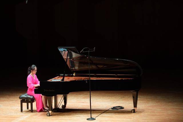 피아니스트 손열음이 모차르트 피아노 소나타 전곡 리사이틀 세 번째 연주회인 6일 예술의전당 콘서트홀 공연 1부에서 마젠타 드레스를 입고 연주하고 있다. 파이플랜즈 제공