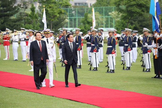 Korean President Yoon Suk Yeol, left, and Japanese Prime Minister Fumio Kishida, right, observe an honor guard during a welcoming ceremony at the Yongsan presidential office in central Seoul Sunday ahead of their bilateral summit. [JOINT PRESS CORPS]