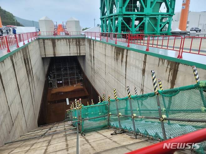 [고흥=뉴시스]누리호 발사 직후 분출되는 고열의 불꽃을 제어하기 위한 발사대의 '화염 유도로'. 좌측 상단의 주황색 원뿔형 물체가 있는 위치에 누리호가 기립하게 된다. 누리호가 기립하는 위치 바로 아래 항우연 관계자들이 화염의 온도, 압력 등을 측정하기 위한 센서를 설치하고 있다. (사진=윤현성 기자)