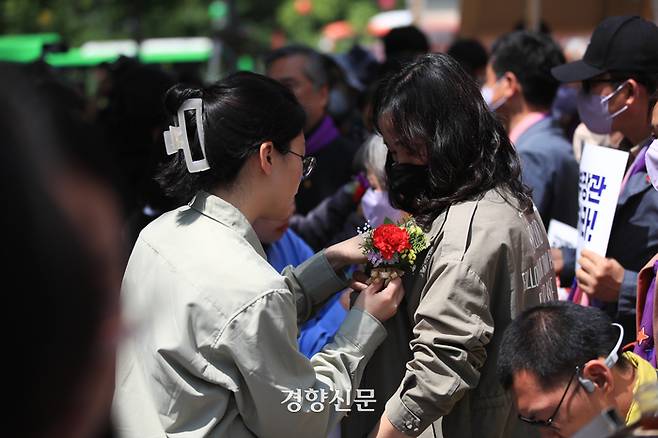 8일 서울광장에서 ‘10.29 이태원 참사 200일. 200시간 집중추모행동 주간 선포 기자회견’을 마친 대학생들이 유가족에게 카네이션을 달아주고 있다. 이준헌 기자