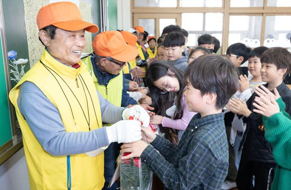 8일 부산진구 부전초등학교 6학년 학생들이 어버이날을 맞아 학교 업무를 봐주시는 시니어 자원봉사단 어르신들께 감사의 마음을 담은 편지와 꽃을 전달하고 있다. 이원준 기자 windstorm@kookje.co.kr