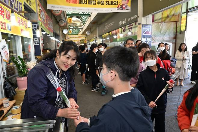 문창초등학교 학생들이 문창전통시장 상인들에게 카네이션을 전달하는 모습. 중구 제공