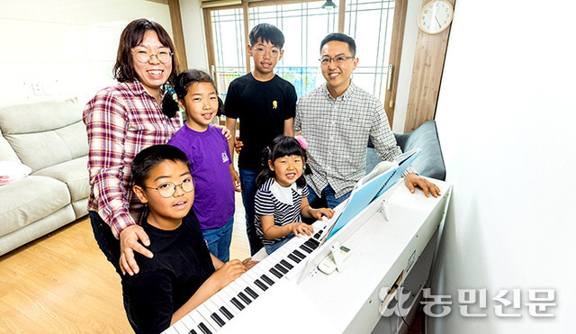 막내 샘물양(앞줄 왼쪽 두번째)이 가족들 앞에서 피아노를 치고 있다.