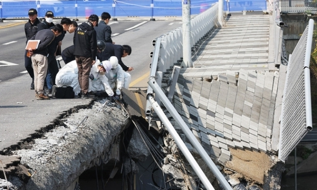 보행로가 무너지며 두 명의 사상자가 발생한 경기도 성남시 정자교에서 지난달 7일 경찰과 국과수 등 관계자들이 사고 원인을 찾기 위한 합동 감식을 하고 있다.   연합뉴스