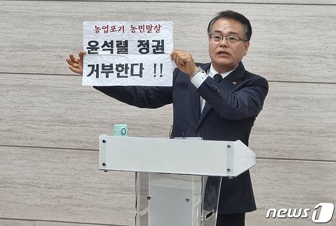 충북의 한 대안학교 학부모가 자녀가 다니는 학교 교사들이 학생들을 극장에 데려가 영화를 보여주면서 손에 들고 사진을 찍게한 손팻말을 들어 보이고 있다./뉴스1