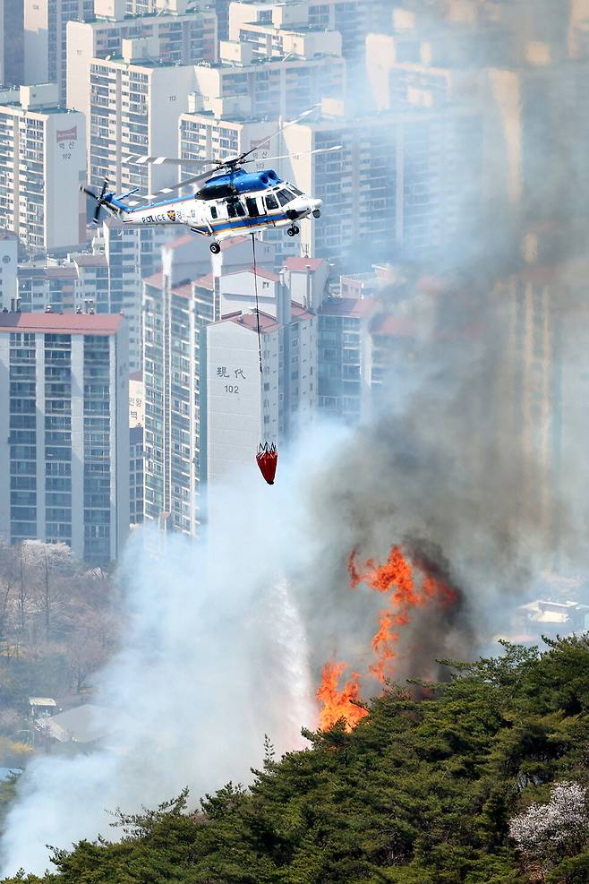 서울 도심 인왕산에 산불이 난 4월2일 소방헬기가 진화 작업을 벌이고 있다. 뒤편에 아파트 단지가 빼곡하다.