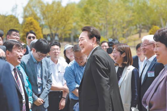 President Yoon Suk Yeol, center, speaks to reporters at an event marking the opening of the Yongsan Children's Garden in front of the presidential office in central Seoul on May 2 ahead of the one-year anniversary of his inauguration. [PRESIDENTIAL OFFICE]