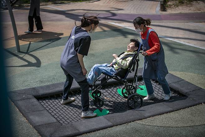 뇌병변 장애 아동 김연우 군(10)이 트램펄린을 타고 있다. 통합놀이터의 트램펄린은 턱 없이 바닥에 설치되어 휠체어 진입이 가능하다. ⓒ시사IN 박미소