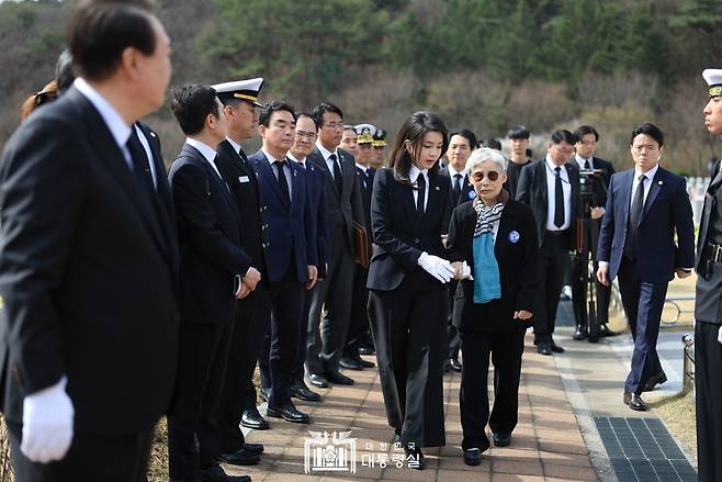 3월24일 천안함 용사 묘역에서 김건희 여사가 한 유족을 위로하는 모습을 윤석열 대통령이 보고 있다.ⓒ대통령실 제공