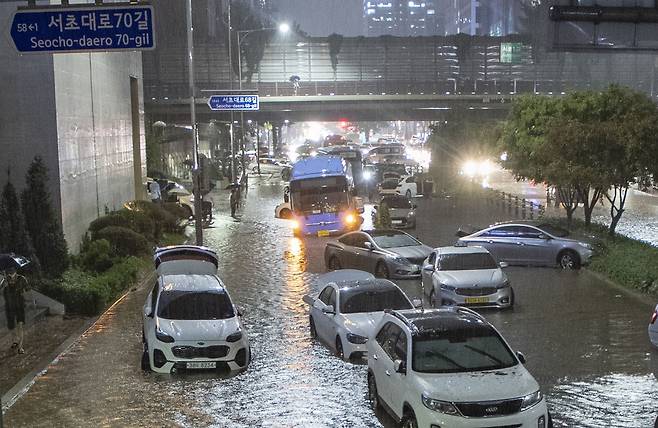 지난해 8월 8일 밤 서울과 경기북부 등 수도권에 기록적인 폭우가 내린 가운데 서울 강남역 일대 도로가 침수되어 시민들이 대피한 후 차들이 도로에 그대로 놓여있다. /조선DB