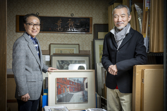 Art collectors Kim Tae-sup, left, and Yoon Young-ju stand with artist Won Guei-hong's paintings at Kim's house, which was once Won's house. [JOONGANG SUNDAY]