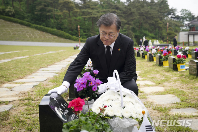 [광주=뉴시스]박영태 기자 = 문재인 대통령이 제40주년 5·18 민주화운동 기념일인 18일 광주 북구 5·18 민주묘지 제2묘역에서 고(故) 이연 씨 묘를 참배하고 있다. 고인은 전남대 1학년에 재학 중이던 1980년 5월 27일 YMCA 회관에서 계엄군과 총격전 중 체포되어 전신 구타를 당했다. 2020.05.18.since1999@newsis.com