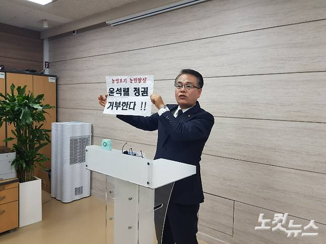 충북도내 모 공립 대안학교의 한 학부모가 지난 9일 기자회견에서 영화 상영회에 참석한 학생들에게 배포됐다는 구호가 적힌 종이를 들어보이고 있다. 김종현 기자