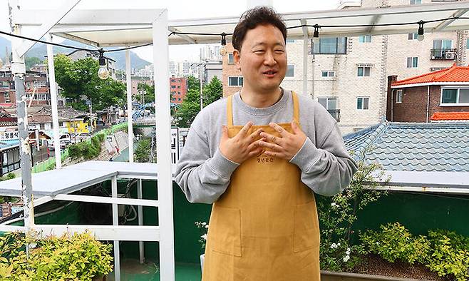 이문수 신부가 지난 4일 사방이 확 트여 ‘청년밥상 문간’의 매력 포인트인 옥상에 올라 현재 위치에 식당을 정하게 된 이유를 설명하고 있다. 남제현 선임기자