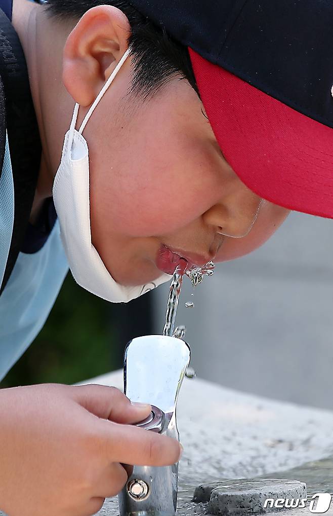 뜨거운 햇살이 내리쬐며 초여름 날씨를 보인 11일 오전 서울 광진구 능동 어린이대공원으로 소풍을 나온 초등학생이 음수대에서 묵을 축이고 있다. 2023.5.11/뉴스1 ⓒ News1 박정호 기자