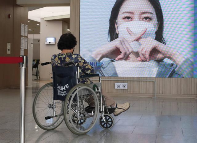 2020년 대한의사협회가 사흘간의 2차 전국의사 총파업에 돌입한 8월 26일 서울 종로구 서울대병원에서 휠체어를 탄 환자가 병원 전광판 앞에서 생각에 잠겨 있다. 뉴스1