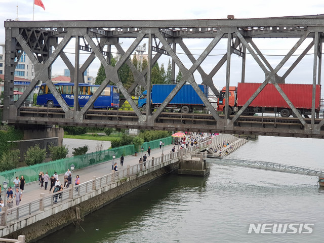 【단둥=뉴시스】 코로나19 상황이 안정화되면서 북한이 이르면 내달 10일께 중국과의 국경을 재개방하고 관광도 전면 재개될 것으로 전해졌다. 사진은 2018년 9월4일 중국 랴오닝 단둥의 압록강 철교(조중우의교)에 북한 트럭이 대기 중인 모습.