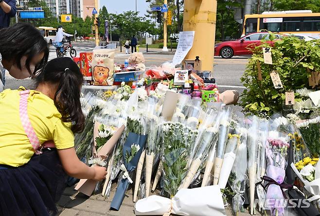 [수원=뉴시스] 김종택 기자 = 11일 경기도 수원시 권선구의 한 사거리에 전날 어리이보호구역(스쿨존)에서 시내버스에 치여 숨진 초등학생을 추모하는 추모 물품들이 놓여 있다. 2023.05.11. jtk@newsis.com