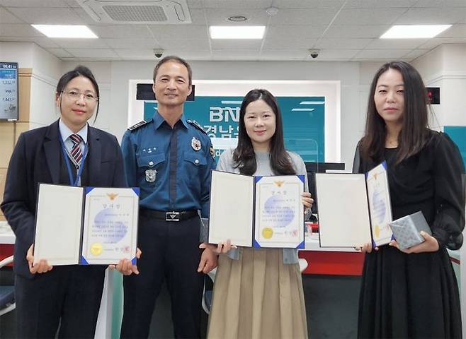 BNK경남은행 양산기업금융지점 직원들이 보이스피싱을 예방한 공로로 양산경찰서 명의의 감사장을 받고 있다.ⓒBNK경남은행