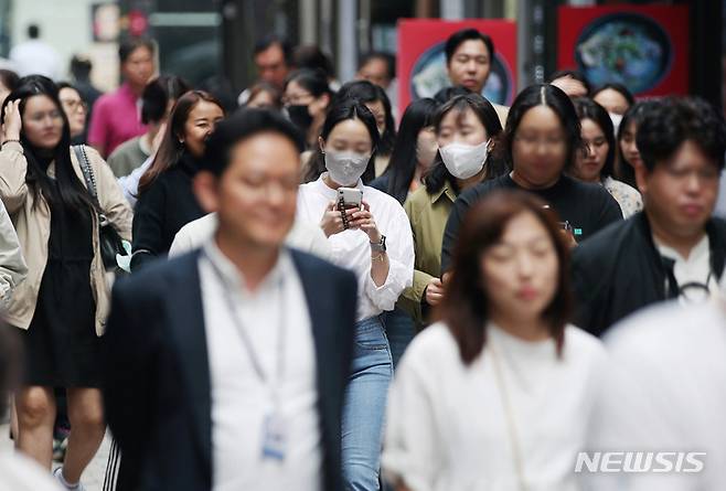 [서울=뉴시스] 김진아 기자 = 정부가 코로나19 위기 경보를 '심각'에서 '경계'로 하향하겠다고 밝혀 사실상 '엔데믹(endemic·풍토병으로 굳어진 감염병)'을 선언한 다음 날인 12일 서울 중구 명동에서 마스크를 쓰거나 쓰지 않은 시민들이 발걸음을 옮기고 있다. 2023.05.12. bluesoda@newsis.com