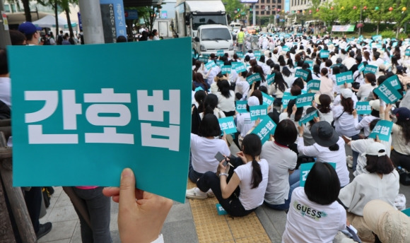 세종대로에 모인 간호사들 ‘간호법 공포하라’ - 국제 간호사의 날인 12일 오후 간호사들이 서울 종로구 광화문 일대에서 열린 ‘2023 국제간호사의 날 기념 축하 한마당’ 행사에서 팻말을 들고 있다.  연합뉴스