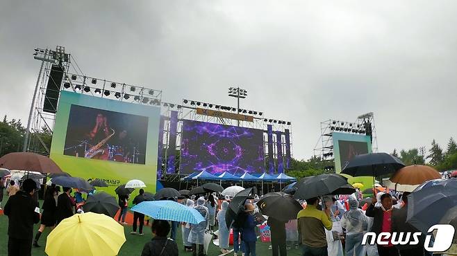 우산을 쓰고 비옷을 입은 시민들이 13일 울산 남구 장생포에서 열린 '2023 울산고래축제' 메인 무대에서 진행된 '미8군 스파르탄 밴드 공연'을 구경하고 있다. 2023.5.13/뉴스1 ⓒ News1 임수정 기자