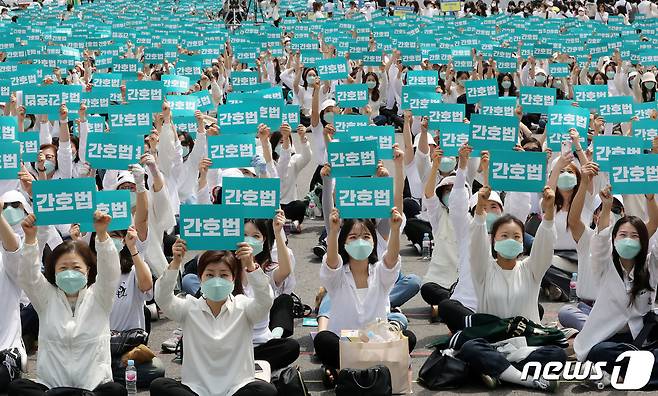 대한간호협회 간호사들이 지난 12일 오후 서울 동화면세점 앞 세종대로에서 열린 국제간호사의 날 기념 집회에서 피켓을 들고 간호법 제정을 촉구하고 있다./뉴스1 ⓒ News1 박세연 기자