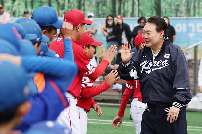 [서울=뉴시스] 전신 기자 = 윤석열 대통령이 14일 서울 용산어린이정원 내 야구장에서 열린 2023 대통령실 초청 전국 유소년 야구대회 결승 경기에 앞서 선수들을 격려하고 있다. (대통령실통신사진기자단) 2023.05.14.