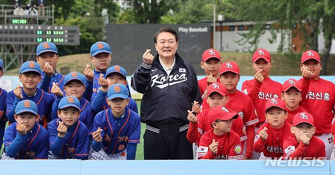 [서울=뉴시스] 전신 기자 = 윤석열 대통령이 14일 서울 용산어린이정원 내 야구장에서 열린 2023 대통령실 초청 전국 유소년 야구대회 결승 경기에 앞서 선수들과 기념촬영하고 있다. (대통령실통신사진기자단) 2023.05.14. photo1006@newsis.com