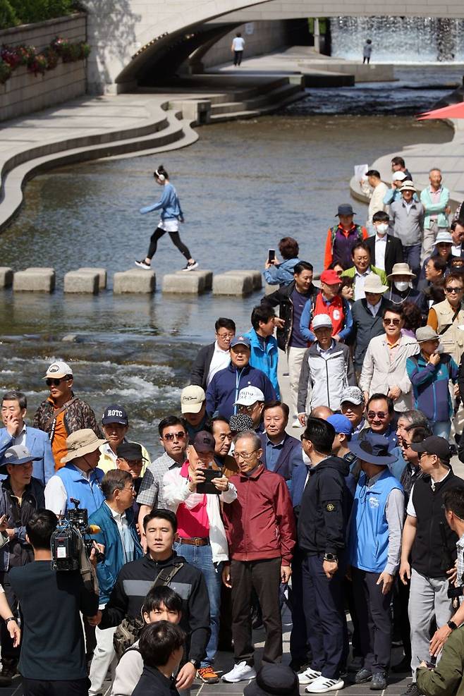 이명박 전 대통령이 15일 서울 청계천에서 옛 참모들과 함께 산책하고 있다. 사진=서동일 기자