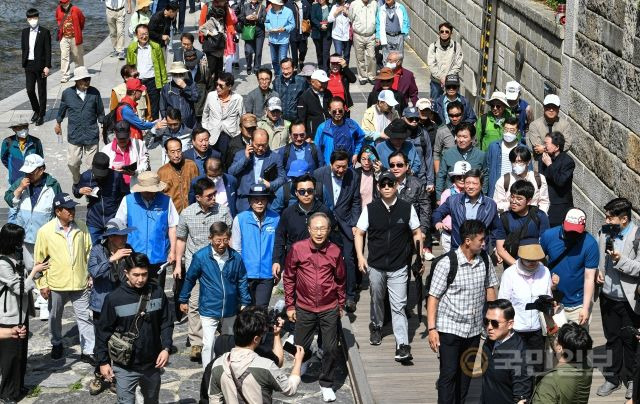 이명박 전 대통령이 15일 서울 청계광장에서 서울시장 재임 당시 청계천 복원사업에 함께했던 서울시 공무원 모임 '청계천을 사랑하는 모임(청사모)' 회원들과 함께 청계천 산책로를 걷고 있다.