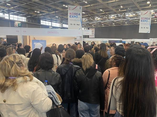 2023 코리아 엑스포에 참가한 SKIN 1004 앞에 관람객들이 구름처럼 몰려 있다.