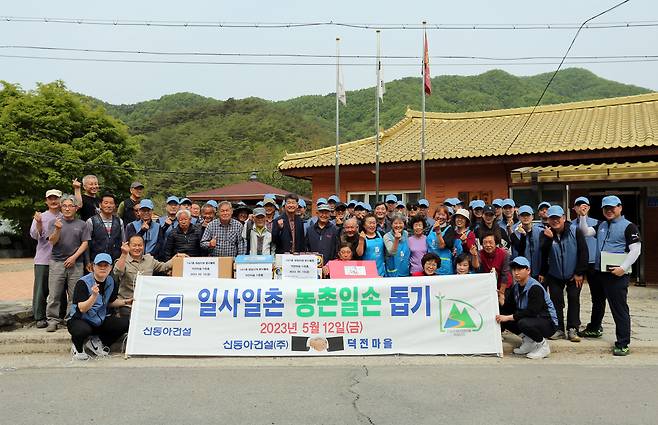 신동아건설 임직원 40여 명이 지난 12일 강원도 영월 덕전마을을 찾아 마을 주민들과 함께 기념촬영을 하고 있다. [신동아건설 제공]