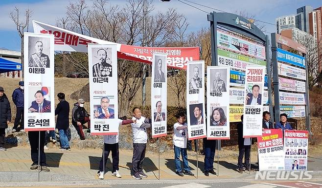 [제천=뉴시스] 이도근 기자= 제천지역 야권과 시민사회단체 회원들이 14일 제천시청 앞에서 열린 '김영환 충북지사 친일파 망언 규탄대회'에서 윤석열 대통령, 박진 외교부장관 등 5명과 친일파 발언 논란을 빚은 김영환 충북지사를 '을사오적'에 빗댄 '계묘오적'으로 지칭한 만장기를 들어 보이고 있다. 2023.3.14. nulha@newsis.com