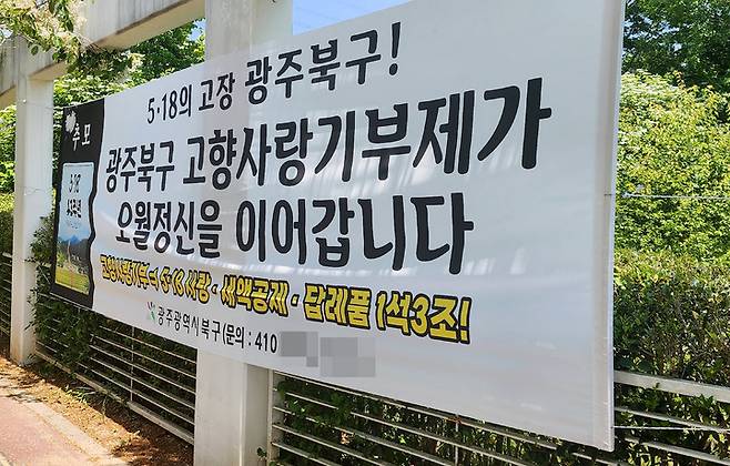 [광주=뉴시스] 변재훈 기자 = 지난 14일 오전 광주 북구 운정동 국립 5·18민주묘지 앞에 내걸린 '광주 북구 고향사랑기부제 홍보 현수막'. 2023.05.14. wisdom21@newsis.com *재판매 및 DB 금지