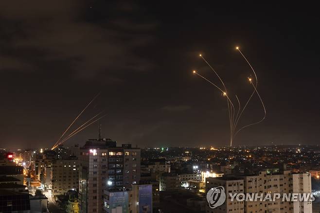 가자지구에서 발사된 로켓 포탄(왼쪽)과 이를 요격하기 위해 이스라엘의 저고도 방공망 아이언돔에서 발사된 미사일(오른쪽)의 궤적. [AP 연합뉴스 자료사진. 재판매 및 DB 금지]