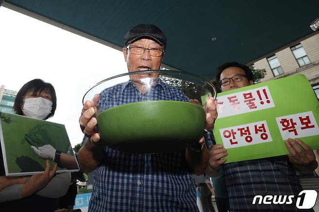 낙동강네트워크·낙동강대구경북네트워크 등 영남권 환경단체 회원들이 지난해 8월1일 대구시청 동인청사 앞에서 대구 수돗물 녹조 독소 오염 파동에 대한 환경부와 대구시의 대책 마련을 촉구하는 기자회견을 열면서 낙동강 강물을 보여주고 있다. ⓒ News1 공정식 기자