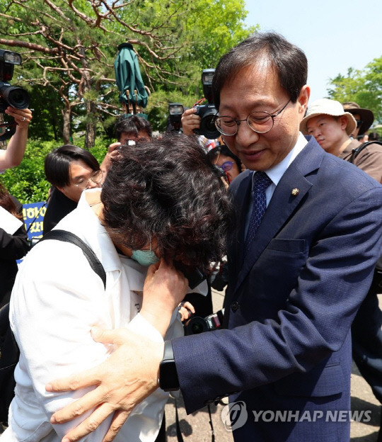 김성주 더불어민주당 정책위 부의장이 윤석열 대통령이 간호법 제정안에 대한 거부권을 행사한 16일 오전 서울 용산구 대통령 집무실 앞에서 거부권 결정 규탄 기자회견을 마친 뒤 대한간호협회 관계자를 위로하고 있다.<연합뉴스>