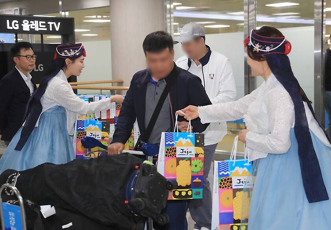 지난 1일 오후 3년 여 만에 재개된 제주∼베이징 직항노선 항공편을 타고 온 중국인 개별 관광객들이 제주국제공항에 도착해 제주관광공사와 대한항공 관계자 등으로부터 환영받고 있다. 연합뉴스