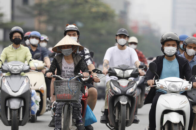 베트남 수도 하노이에서 마스크를 쓴 사람들이 오토바이를 타고 있다. [연합]