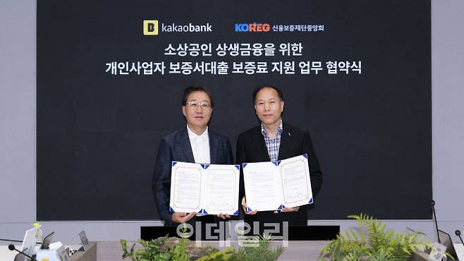 윤호영 카카오뱅크 대표(왼쪽)와 신용보증재단중앙회 이상훈 회장이 지난 16일 카카오뱅크 판교오피스에서 진행된 ‘소상공인 상생금융을 위한 보증료 지원 업무 협약 체결식’에서 기념 촬영을 하고 있다. (사진=카카오뱅크)