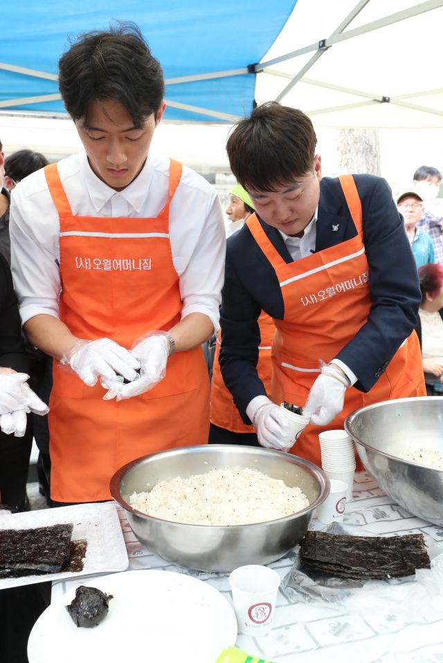 전두환 전 대통령 손자 전우원씨와 이준석 전 국민의힘 대표가 17일 광주 동구 금남로에서 열린 '오월 주먹밥' 나눔 행사에 참여하고 있다. 연합뉴스