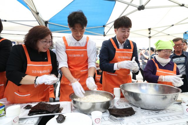 전두환 전 대통령 손자 전우원씨와 이준석 전 국민의힘 대표가 17일 광주 동구 금남로에서 열린 '오월 주먹밥' 나눔 행사에 참여하고 있다. 연합뉴스