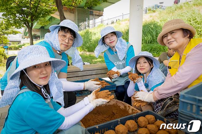 코웨이 임직원 봉사자가 'EM흙공'을 제작하는 모습(코웨이 제공)