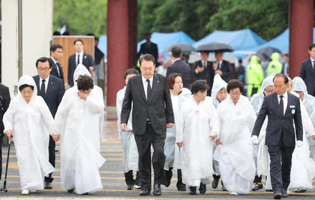 윤석열 대통령이 18일 광주 북구 국립 5·18 민주묘지에서 열린 제43주년 5·18민주화운동 기념식에 오월어머니회 회원들과 함께 입장하고 있다. 광주=연합뉴스