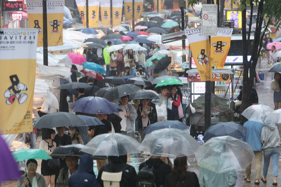 전국에 비가 내리고 있는 5일 오후 서울 중구 명동거리에서 관광객들이 우산을 쓰고 이동하고 있다. [사진=뉴시스]